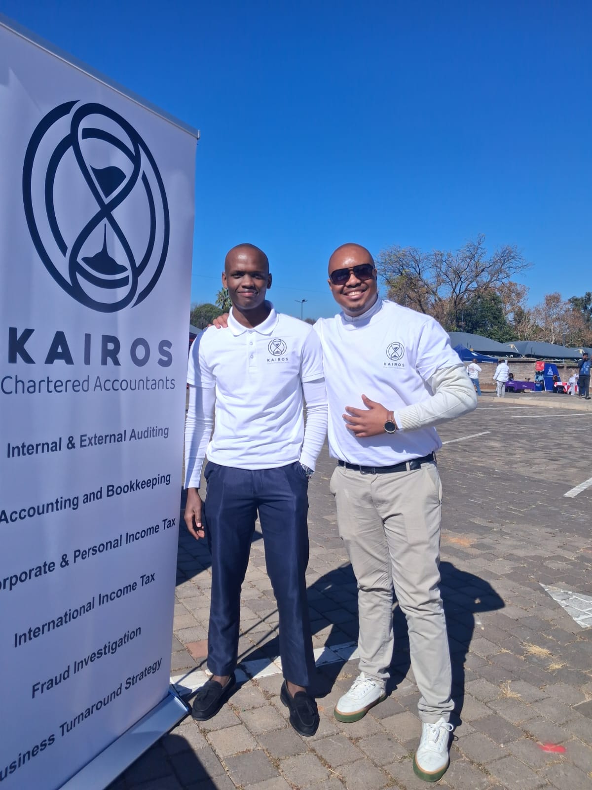 Two members of the KAIROS team beside the KAIROS Chartered Accountants banner at Career Day 2026